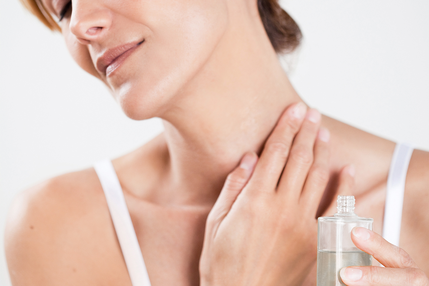 a woman applying oil to her sore, stiff neck