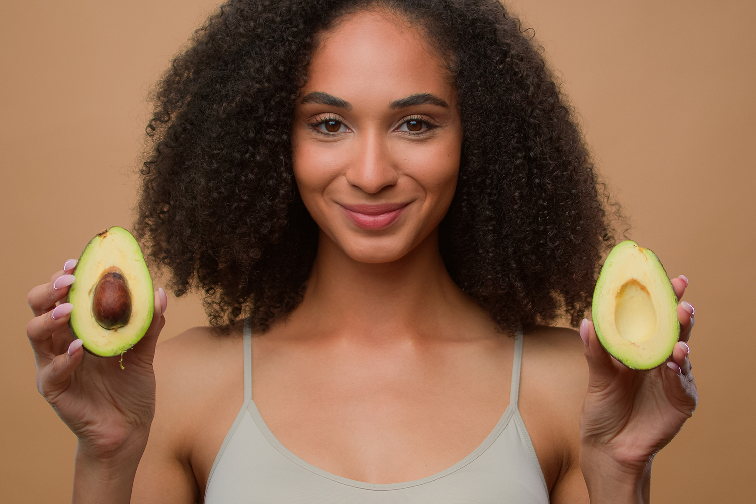 a woman with beautiful skin holding avocados