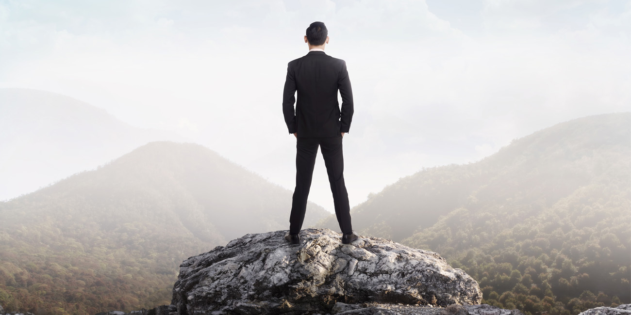 Man in suit stands looking out at the world