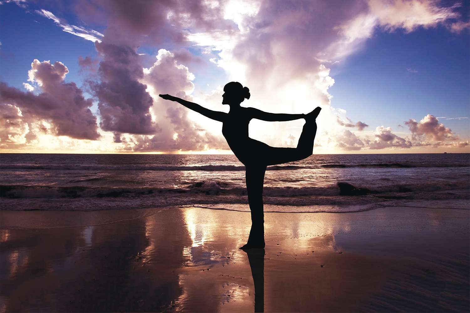 A woman doing yoga on the beach