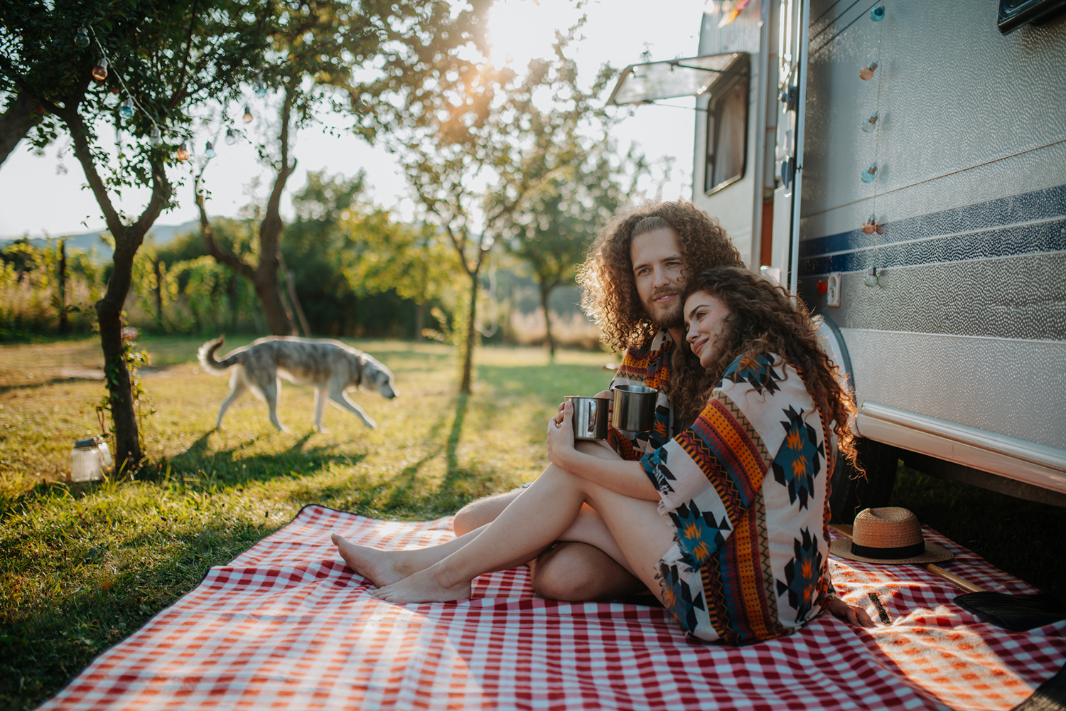a couple drinking herbal tea while camping in a caravan