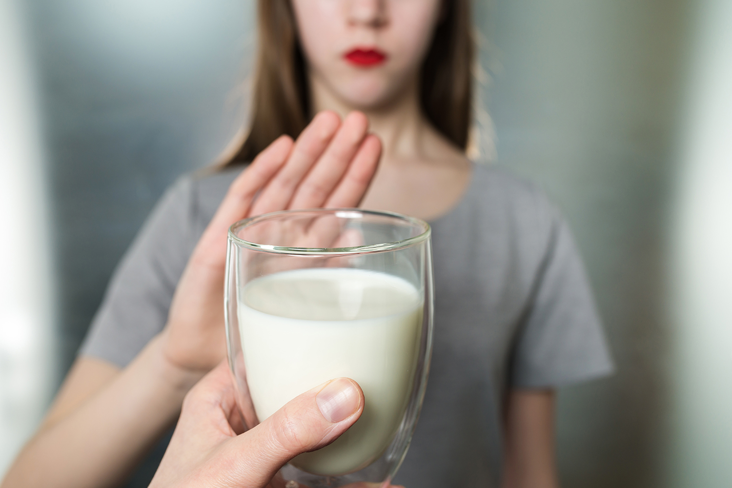 a young woman refusing a glass of milk