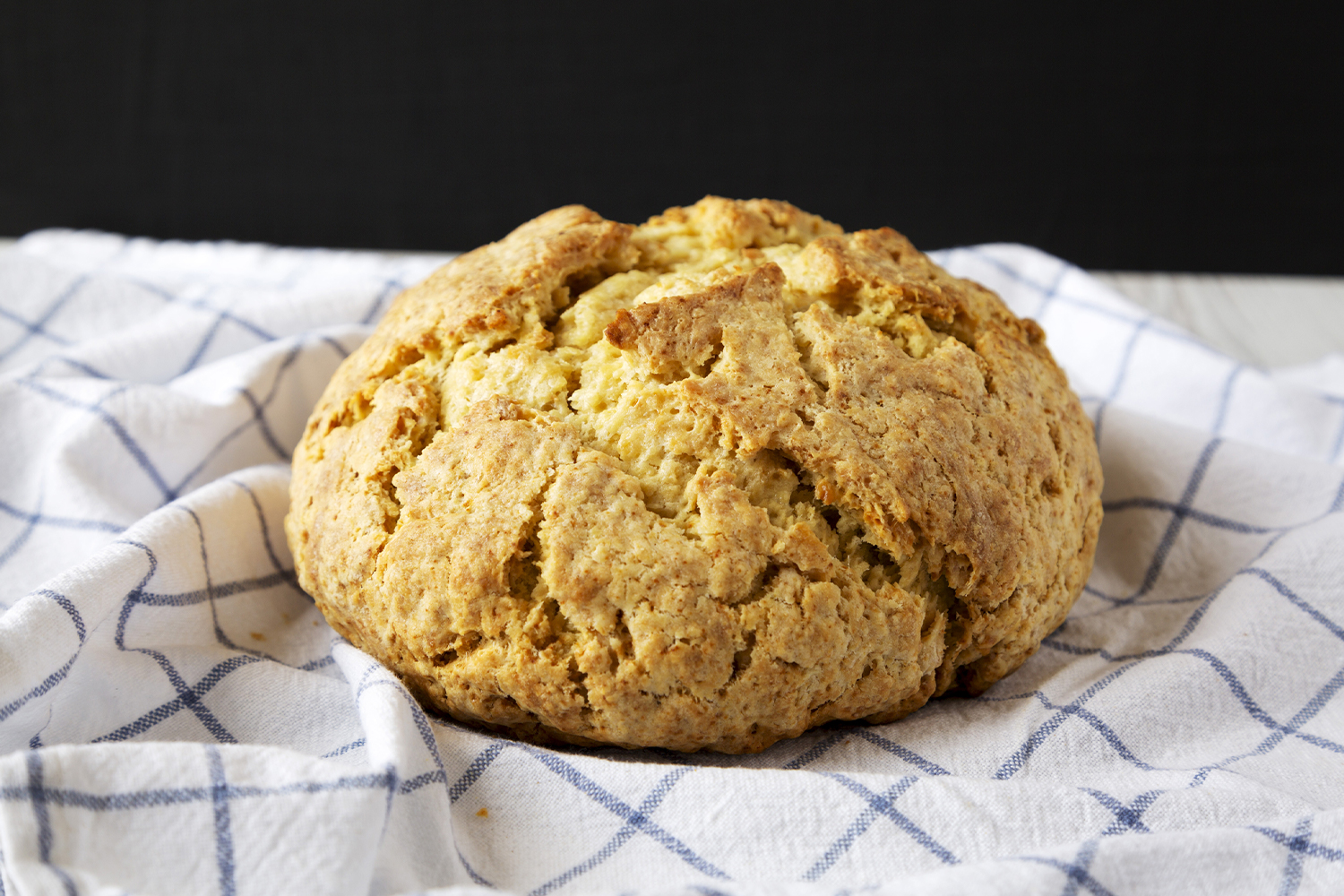 Butternut squash soda bread cooling on a white and blue tea towel.