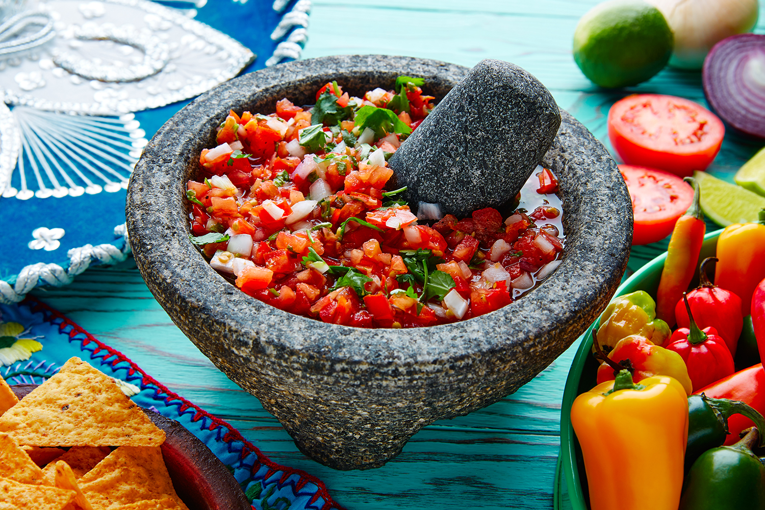 a stone mortar and pestle filled with salsa fresca