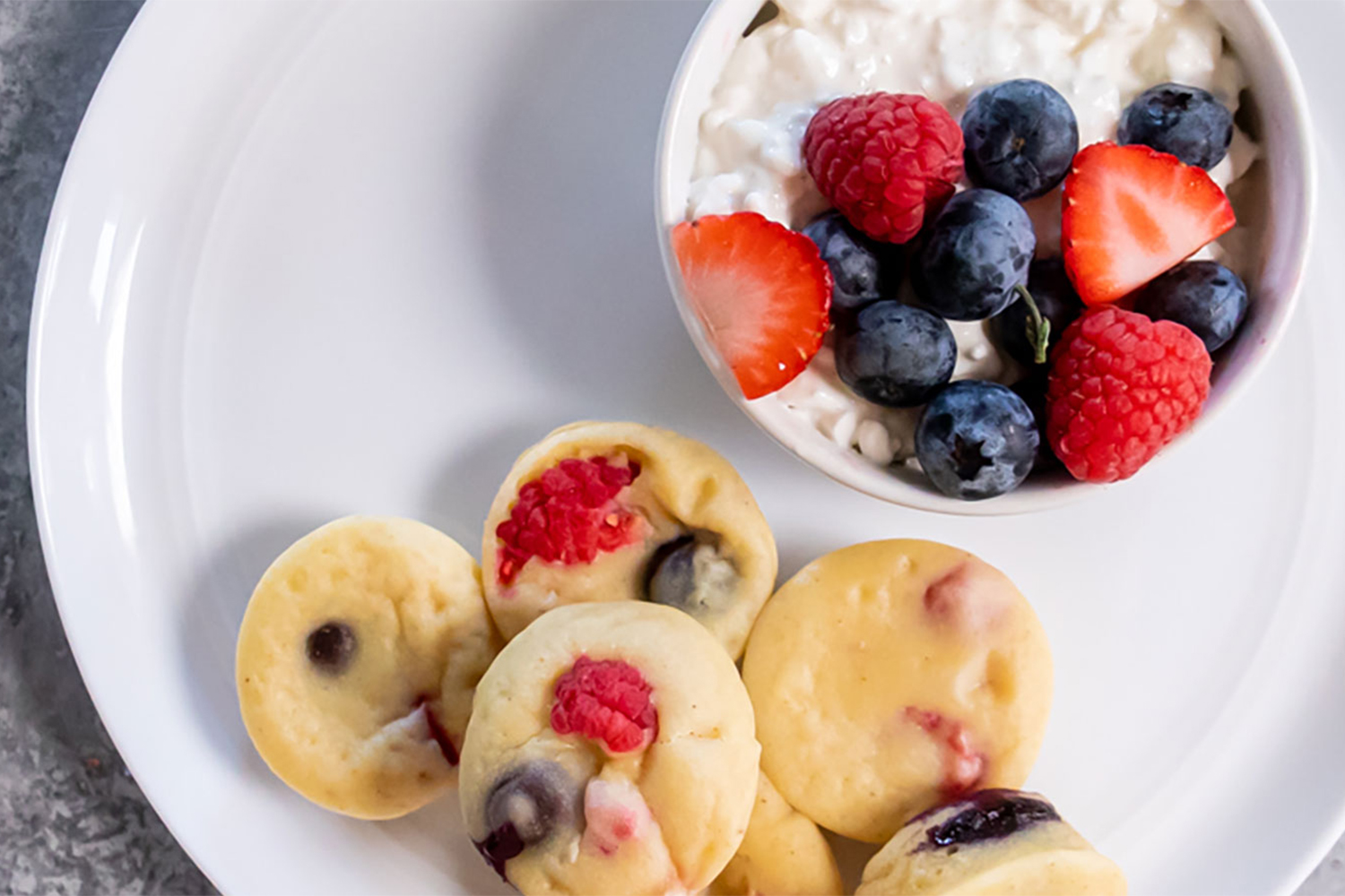 a plate of pancake bites with cottage cheese and berries