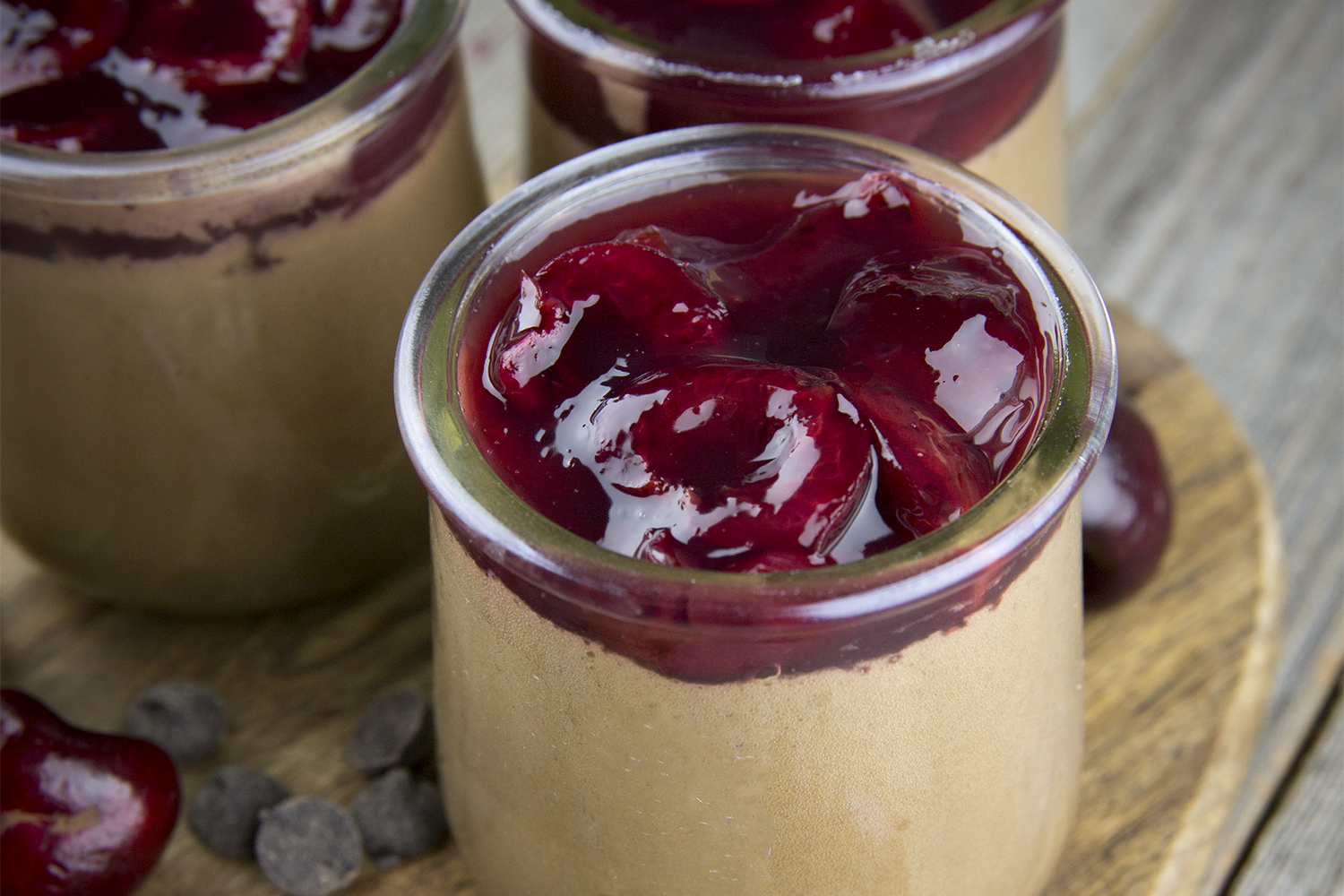 serving jars filled with chocolate mousse with cherries on top