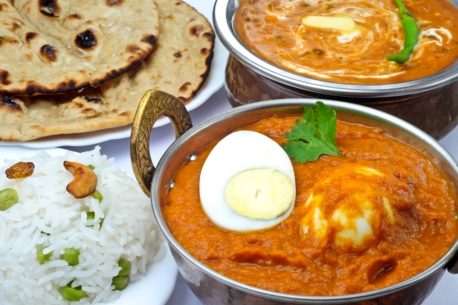 a boiled and sauteed egg in red curry with roti