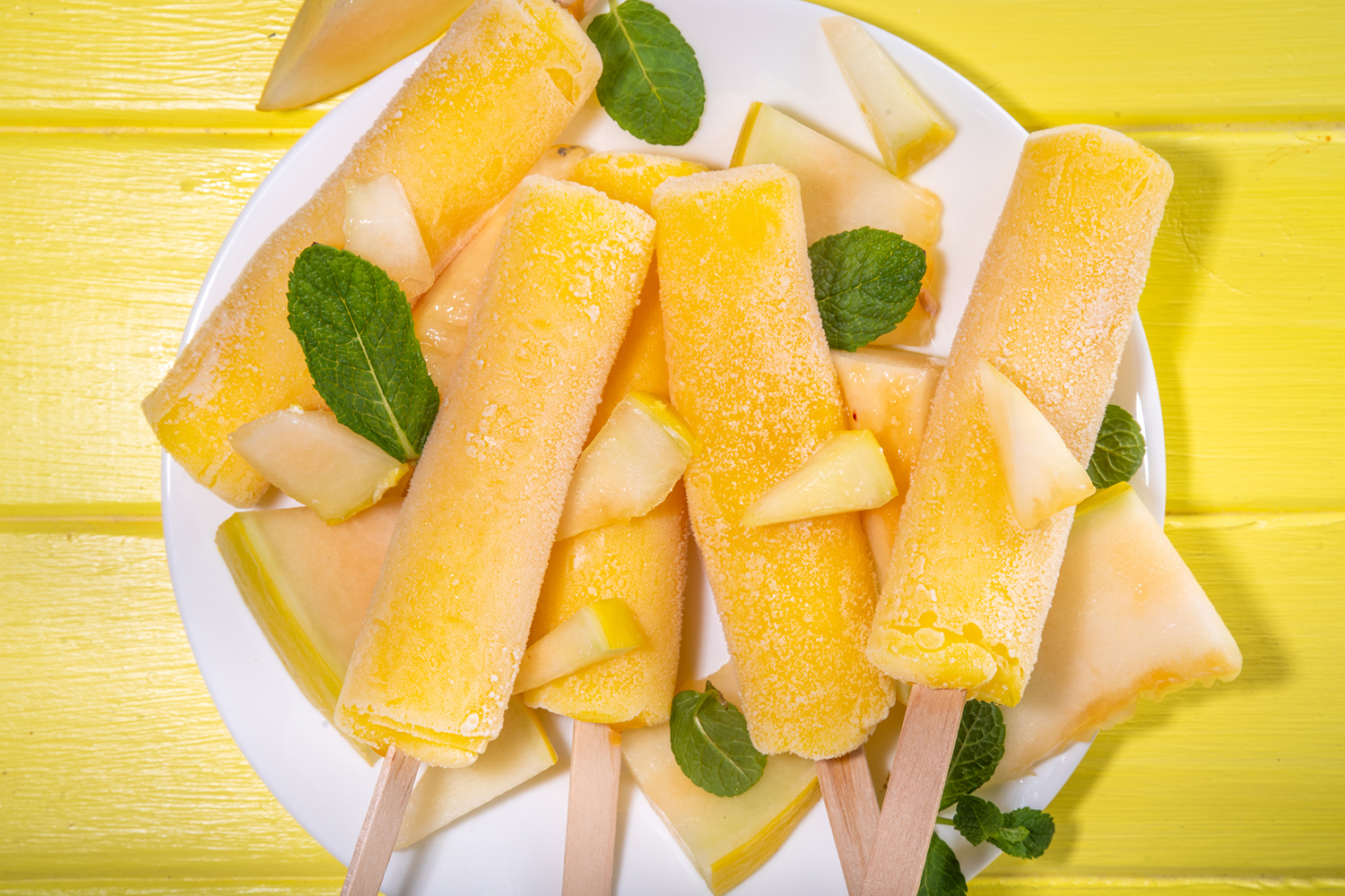 a plate of freshly frozen cantaloupe pops