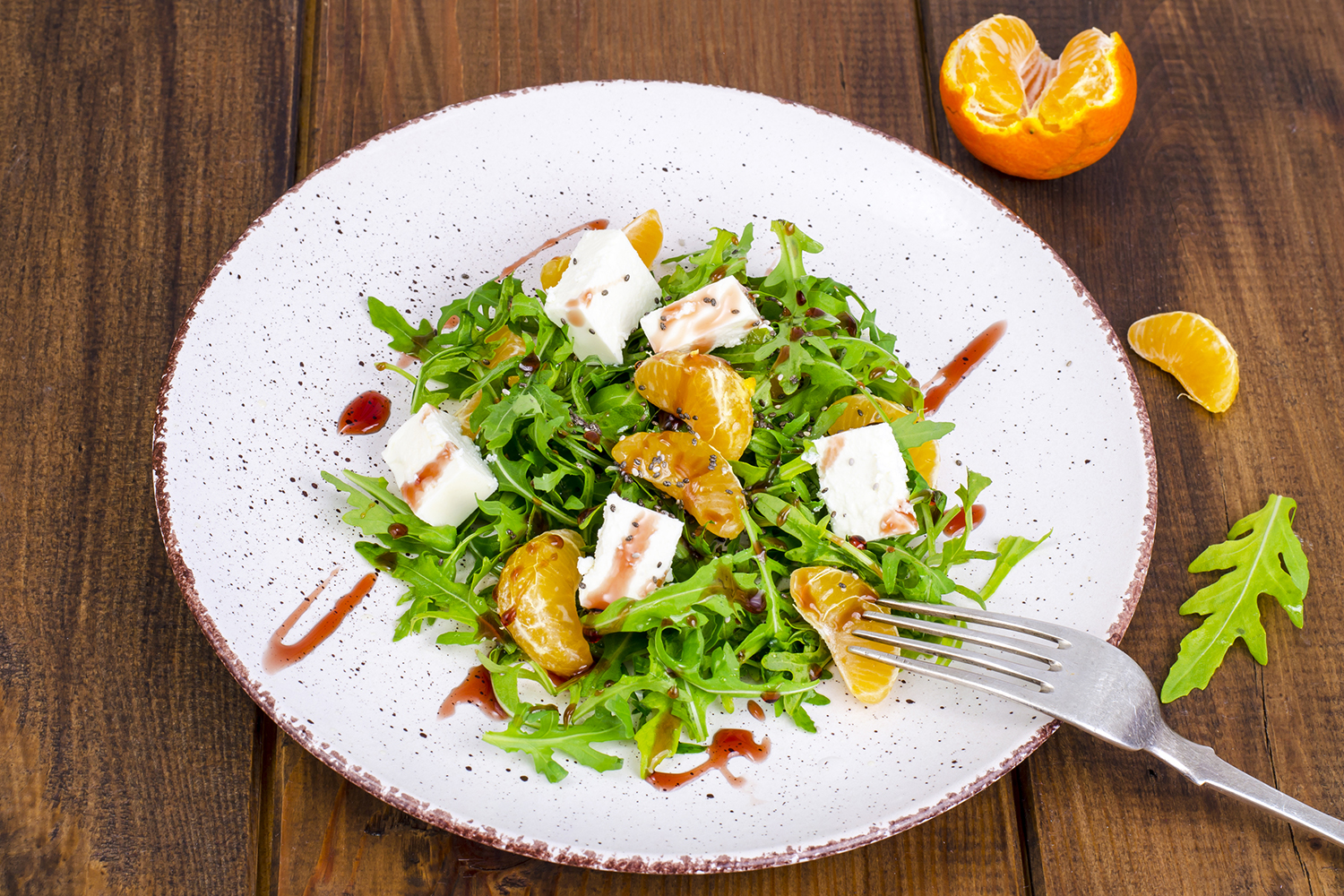 a salad of arugula, tangerines, feta, and seeds