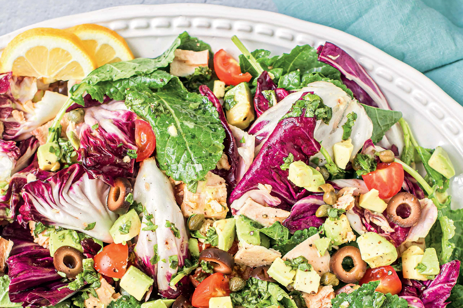 a plate of kale salad with tuna and citrus-basil dressing