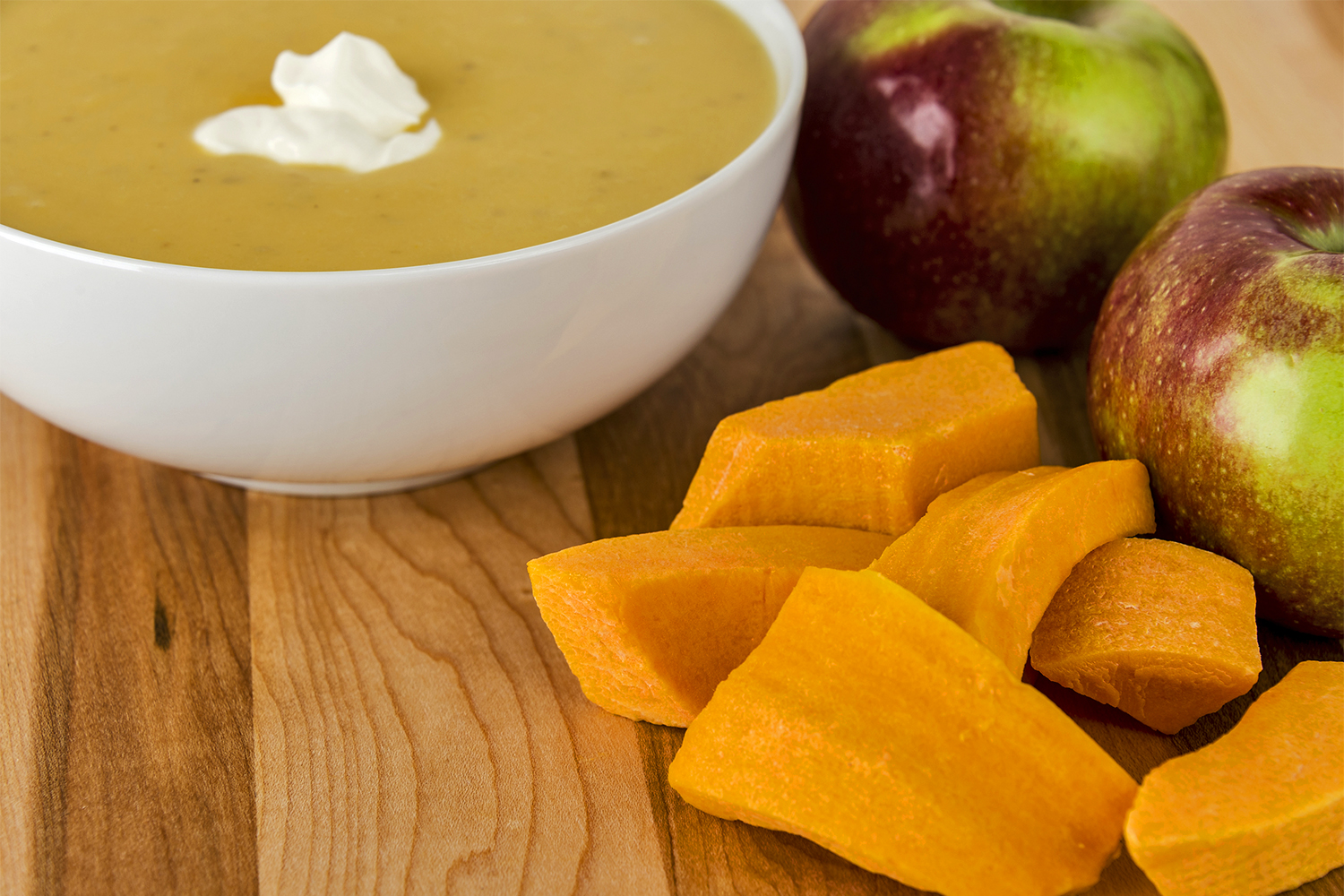 butternut squash, red apples, and a bowl of hearty bisque soup