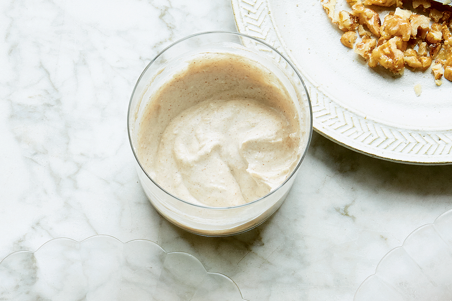 Cashew Sour Cream in a glass on a marble tabletop.