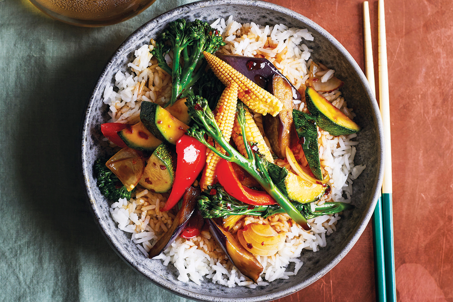 a bowl of stir-fried teriyaki vegetables on a bed of rice
