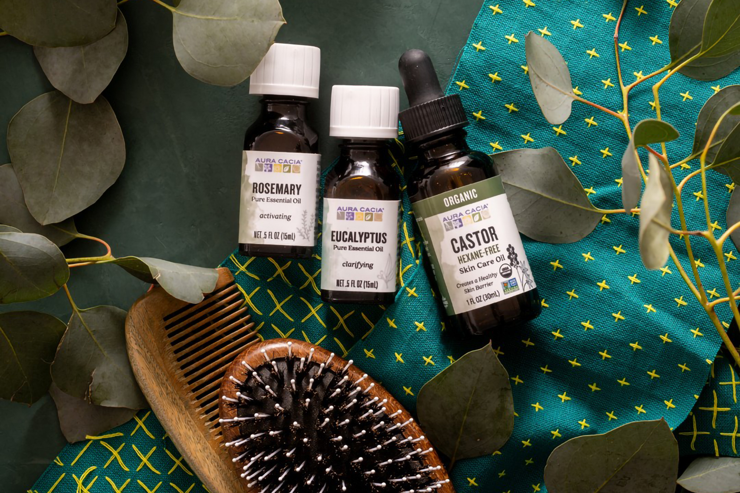 a brush, a comb, and bottles of essential oils