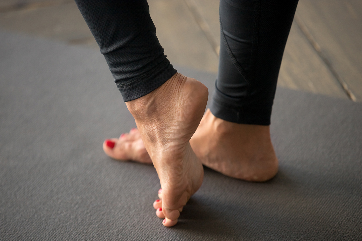A woman doing stretches to strengthen muscles in the foot and ankle.