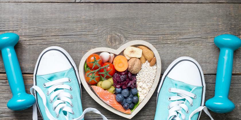 fitness equipment and running shoes next to a bowl of heart-healthy food