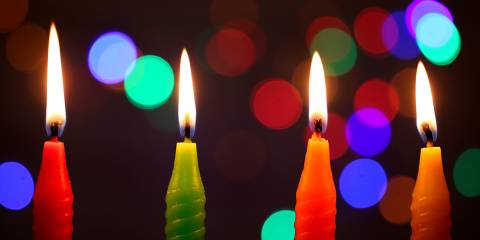 candles in the dark in front of strings of twinkling lights