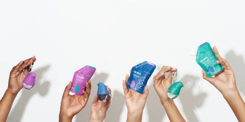 people holding containers of hand sanitizer