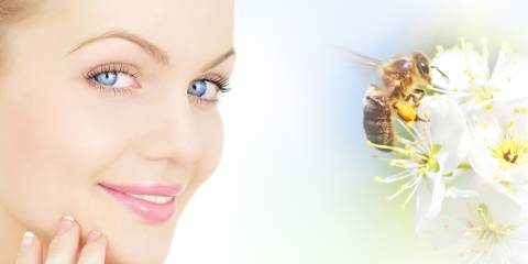 a woman with healthy skin thanking a bee for its products