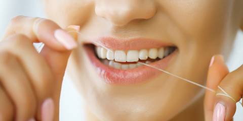 Woman flossing her teeth.
