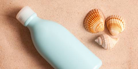 A bottle of sunscreen in the sand