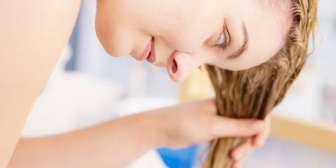 a woman rinsing out her hair in the sink
