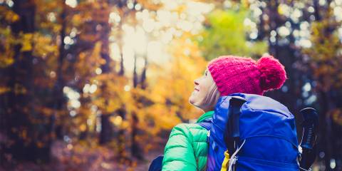 a woman hiking through the fall foliage