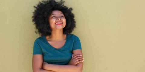 Happy woman with arms crossed looking upwards smiling