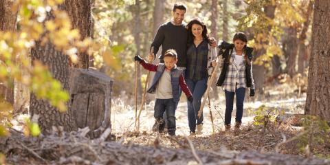 Family of four hiking through the autumn woods.
