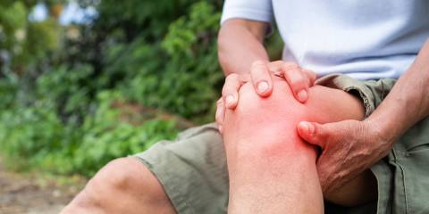 an older hiker grabbing his knee in pain