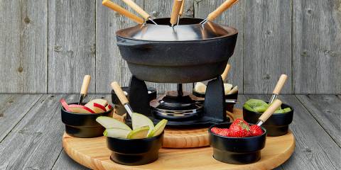 Fruit fondue on a plate on the background of wooden boards