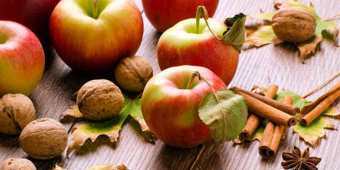 fresh apples, walnuts in the shell, and sticks of cinnamon