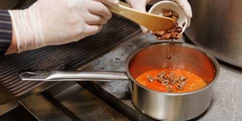 someone cooking a puttanesca sauce with chopped olives and minced anchovies