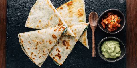 baked spinach quesadillas served on a slate with salsa