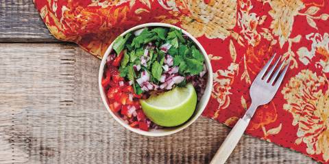 a bowl of salsa on a picnic table