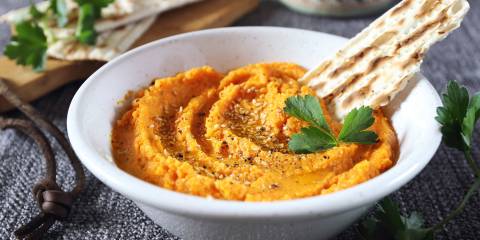 a bowl of carrot dip ready for a party