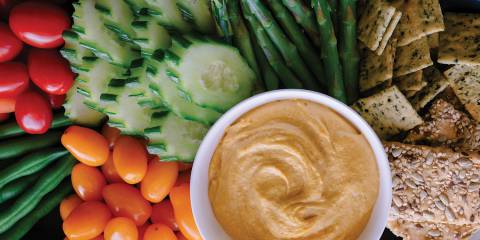 Sweet Potato Cashew Dip on a platter with veggies and crackers.