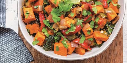 Top view of Chipotle-Sweet Potato Salad in a white bowl on a wooden table.