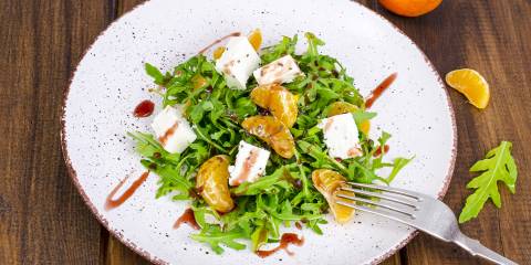 a salad of arugula, tangerines, feta, and seeds