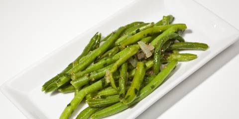 Green beans on a rectangular white plate. 