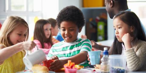 a group of schoolchildren eating lunch together