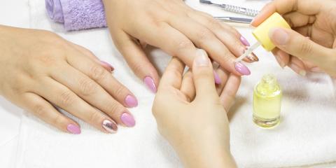 Person getting oil on their cuticles at a manicure. 