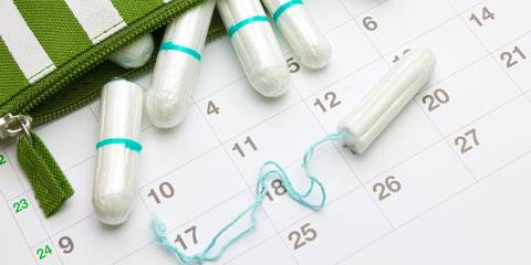 a zipper-case full of tampons resting on a calendar