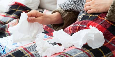 a woman with a pile of used tissues