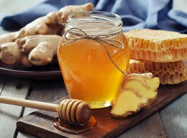 a jar of honey and fresh sliced ginger root